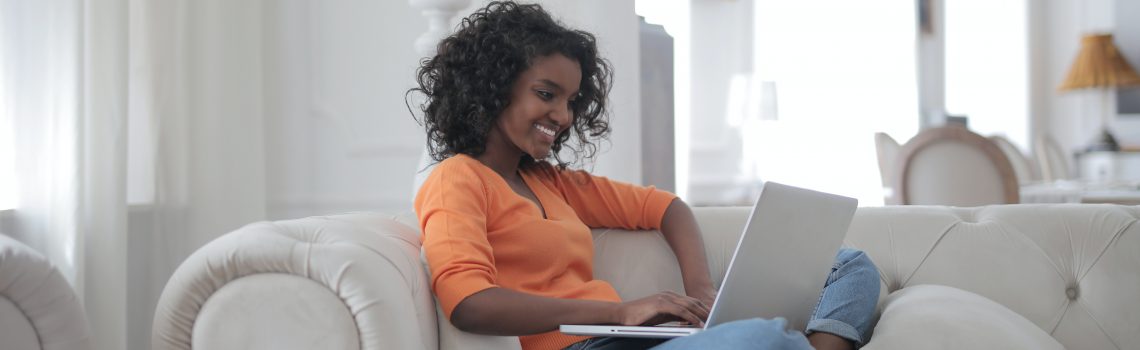 woman-sitting-on-white-couch-using-laptop-computer-3960127